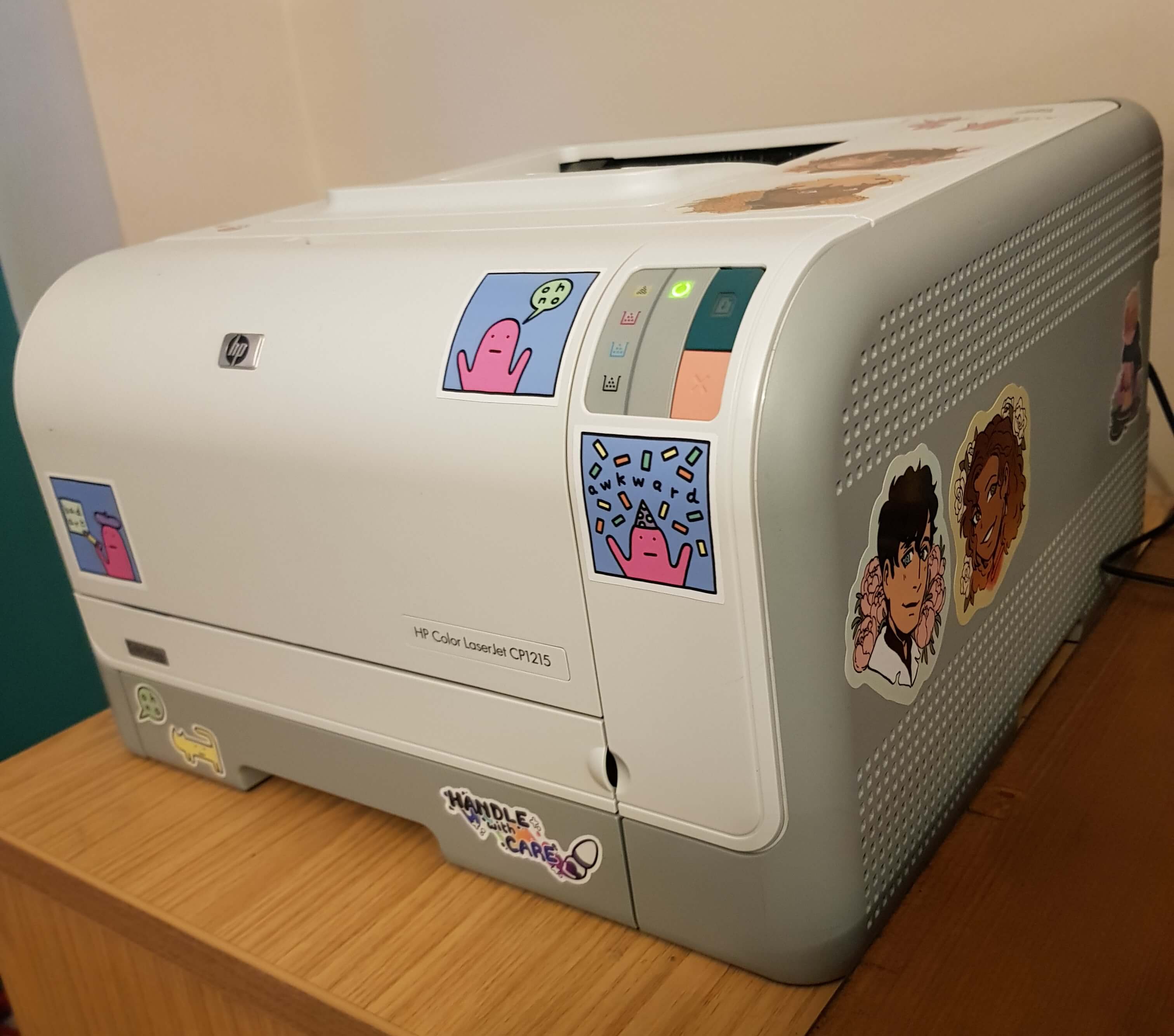 a photo of a little grey laser printer, decorated with colourful stickers